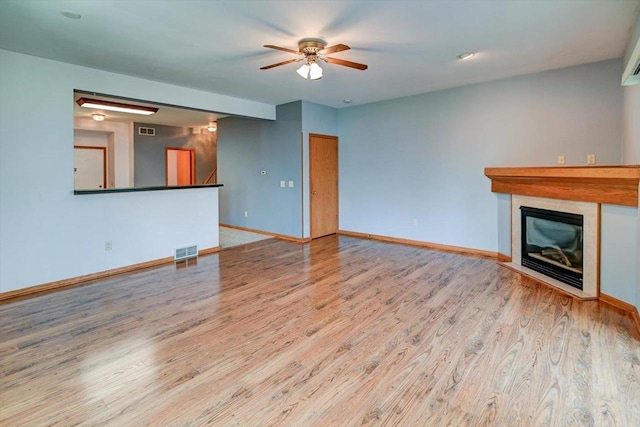 555 Kelvington Dr Unit 4, Sun Prairie, WI 53590 - unfurnished living room featuring wood finished floors, ceiling fan, baseboards, and a glass covered fireplace