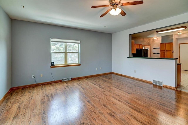 555 Kelvington Dr Unit 4, Sun Prairie, WI 53590 - unfurnished living room with a ceiling fan, light wood-style floors, and baseboards
