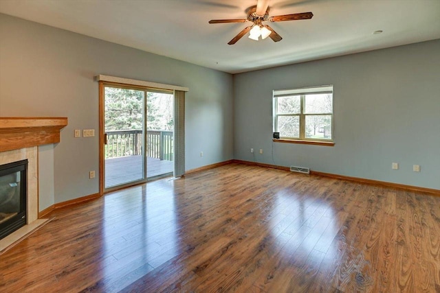 555 Kelvington Dr Unit 4, Sun Prairie, WI 53590 - unfurnished living room with healthy amount of natural light, ceiling fan, a tiled fireplace, and wood finished floors