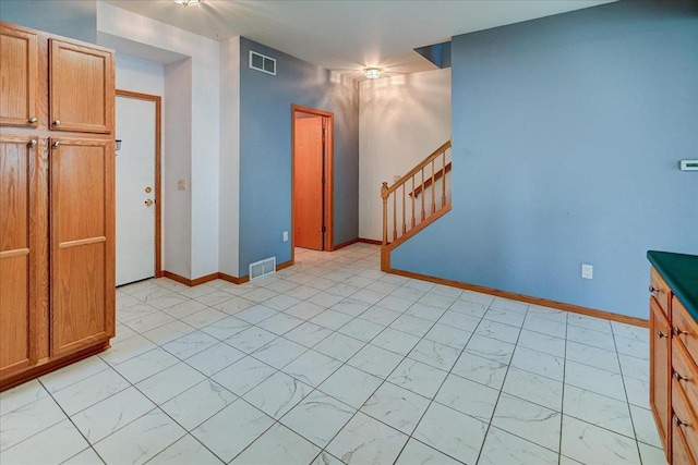 555 Kelvington Dr Unit 4, Sun Prairie, WI 53590 - empty room featuring light marble finish flooring, stairway, and baseboards