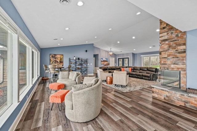 living area with visible vents, wood finished floors, lofted ceiling, a fireplace, and recessed lighting