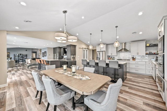dining area featuring recessed lighting, visible vents, lofted ceiling, and light wood-style floors