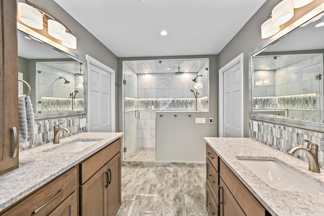 full bath with recessed lighting, a sink, two vanities, and a shower stall