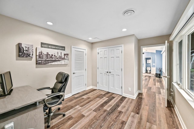 home office with baseboards, recessed lighting, wood finished floors, and visible vents