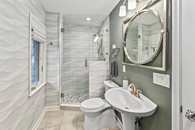 bathroom with a sink, tile patterned floors, a shower stall, and toilet