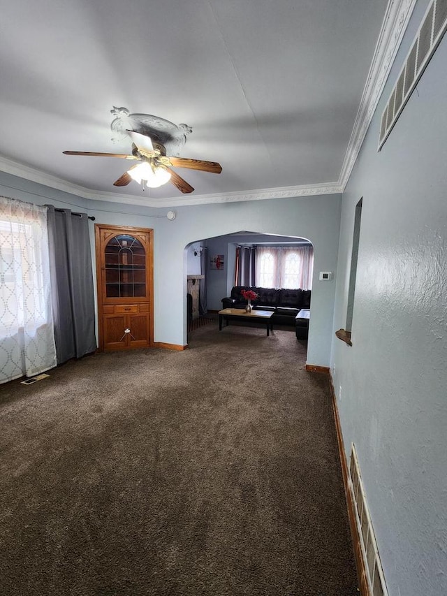 interior space with ceiling fan, visible vents, arched walkways, ornamental molding, and carpet flooring