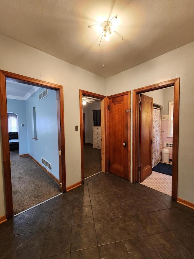interior space with crown molding, arched walkways, baseboards, and visible vents