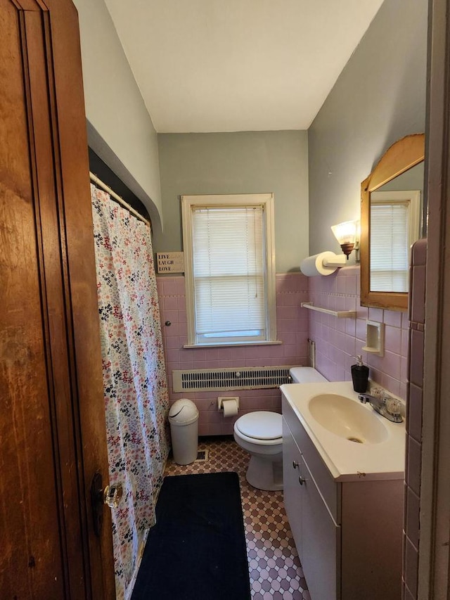 bathroom featuring tile walls, wainscoting, vanity, tile patterned floors, and toilet