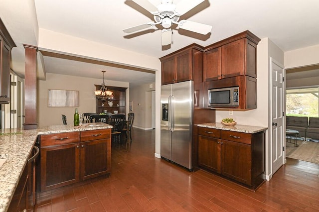 kitchen featuring dark wood-type flooring, a peninsula, light stone countertops, and stainless steel appliances