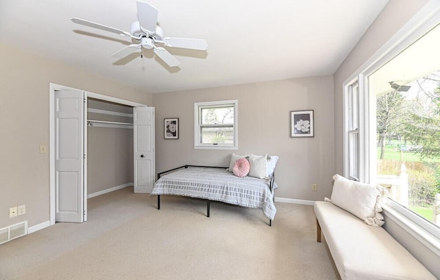 carpeted bedroom featuring visible vents, baseboards, ceiling fan, and a closet