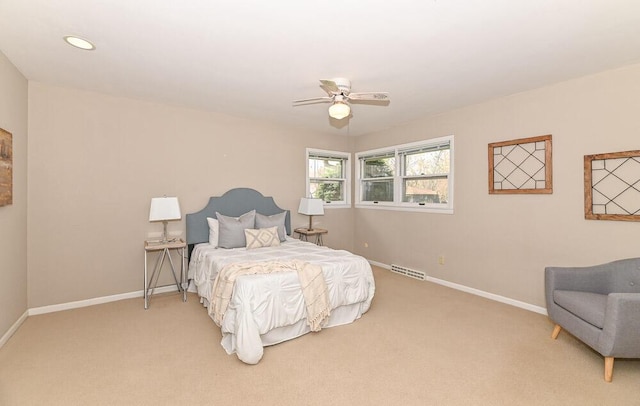 bedroom featuring baseboards, ceiling fan, light carpet, and visible vents
