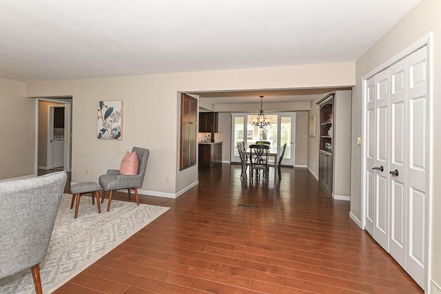 interior space with baseboards, dark wood-style floors, and a notable chandelier