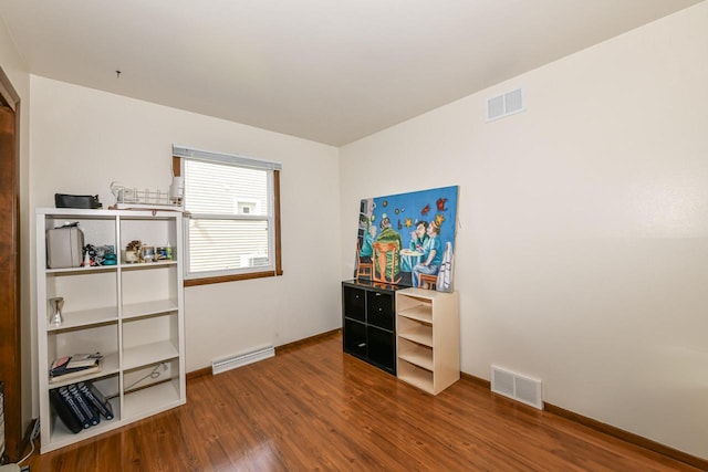 bedroom with baseboards, wood finished floors, and visible vents