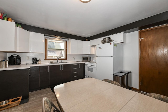 kitchen with a sink, white appliances, light countertops, wood finished floors, and a toaster