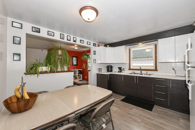 kitchen with a sink, light wood-style flooring, and light countertops