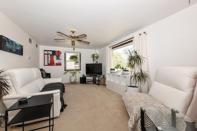 living room with light colored carpet, a ceiling fan, and visible vents