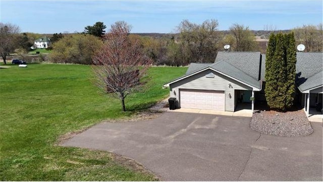 exterior space with a lawn, a garage, and aphalt driveway