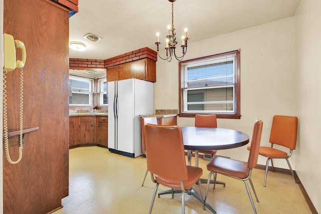 dining room featuring baseboards, a notable chandelier, a wealth of natural light, and visible vents