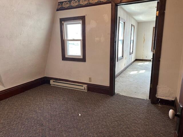 carpeted empty room with baseboards and baseboard heating