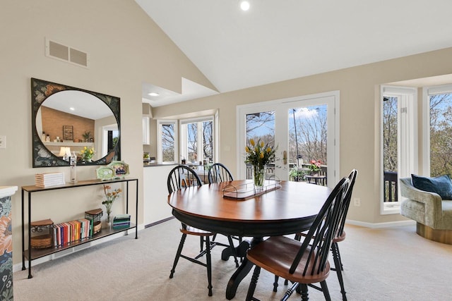 dining room with visible vents, baseboards, a healthy amount of sunlight, and light carpet