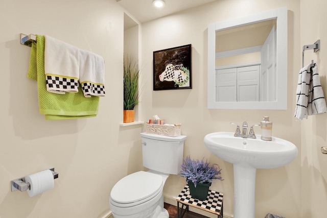 half bath with toilet and a sink