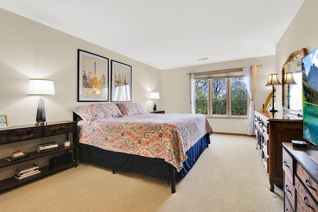 bedroom featuring baseboards, visible vents, and light carpet