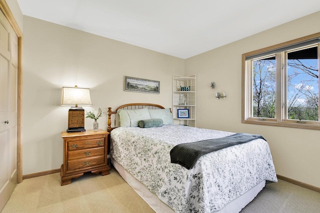 bedroom with baseboards and light carpet