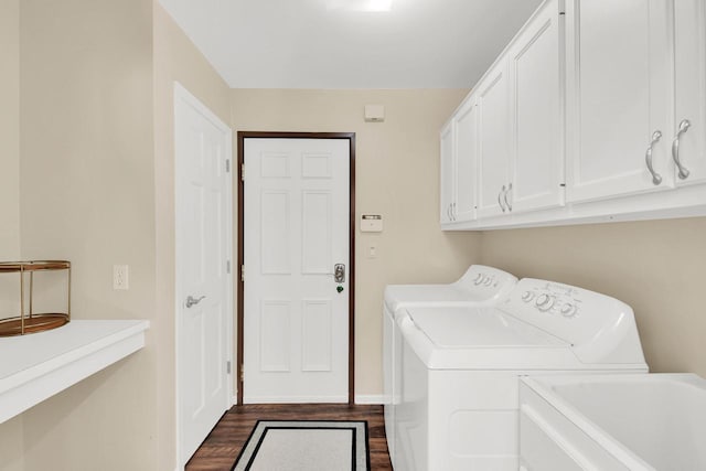 laundry room with a sink, cabinet space, independent washer and dryer, and dark wood finished floors