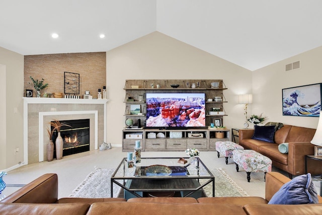 carpeted living area with a fireplace, vaulted ceiling, recessed lighting, and visible vents