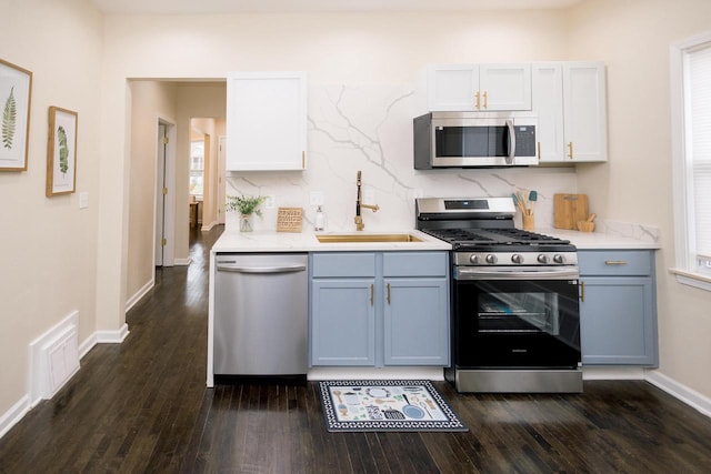 kitchen featuring dark wood-style flooring, a sink, light countertops, stainless steel appliances, and visible vents
