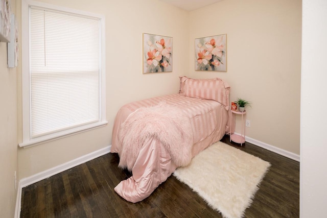 bedroom with baseboards and wood finished floors