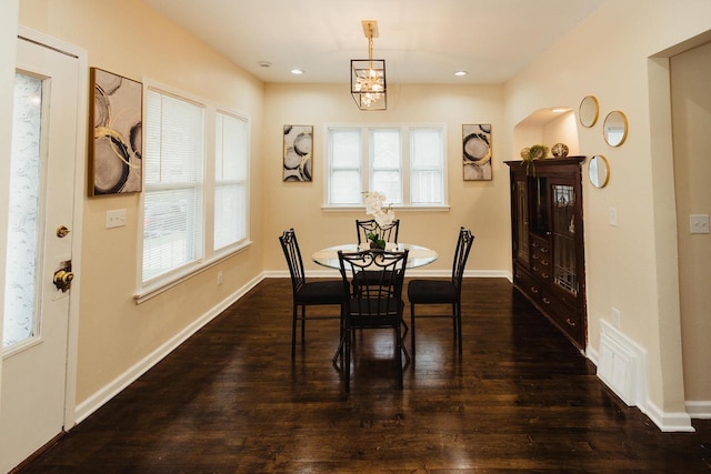 dining space featuring baseboards, visible vents, a wealth of natural light, and dark wood finished floors
