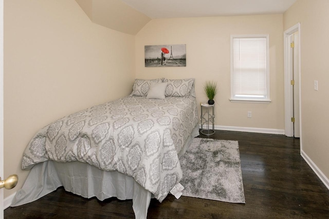 bedroom with baseboards, vaulted ceiling, and wood finished floors