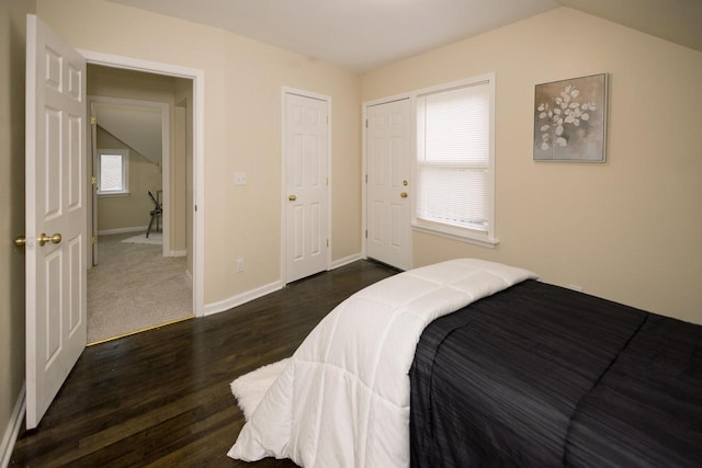 bedroom featuring baseboards, dark wood-style floors, and lofted ceiling
