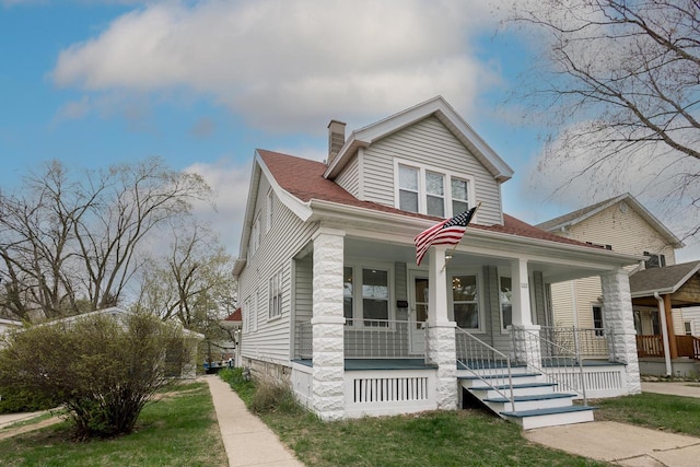 bungalow-style house with a porch and a chimney