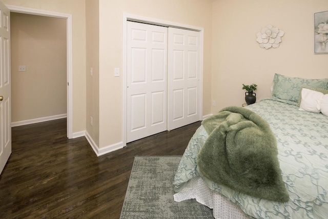 bedroom with a closet, baseboards, and dark wood-type flooring