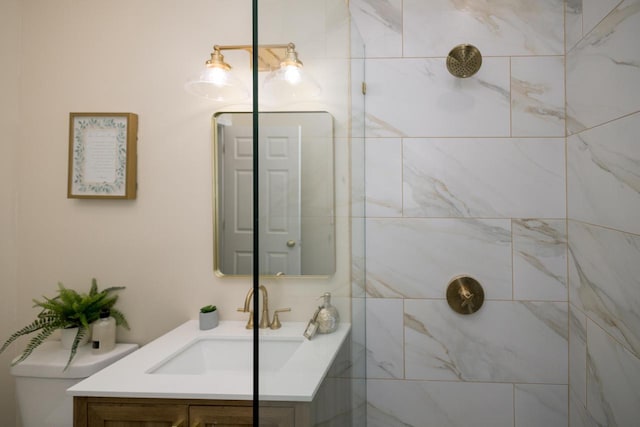 bathroom featuring vanity, toilet, and tiled shower