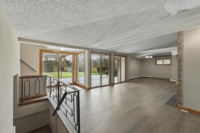 interior space with baseboards, a baseboard radiator, a textured ceiling, and wood finished floors