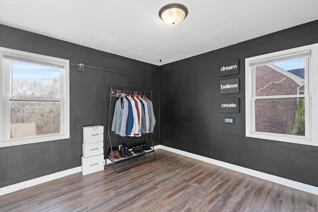 bedroom featuring baseboards, wood finished floors, and a closet