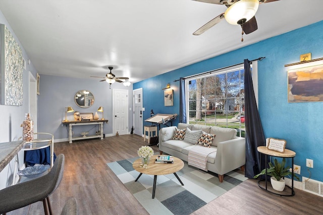 living room featuring baseboards, ceiling fan, wood finished floors, and visible vents