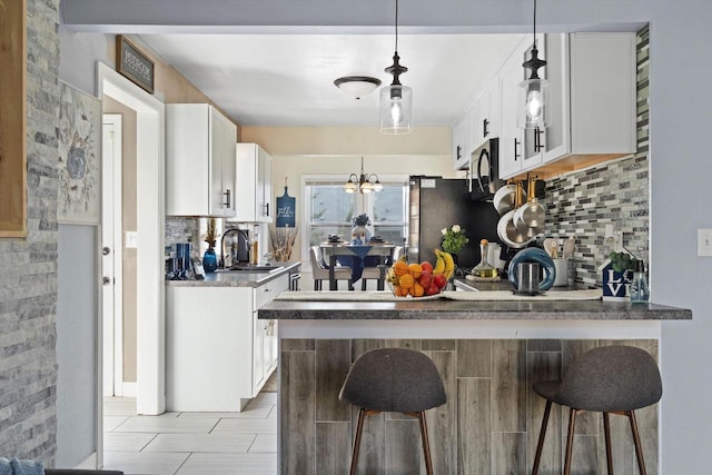 kitchen with white cabinetry, a sink, and tasteful backsplash