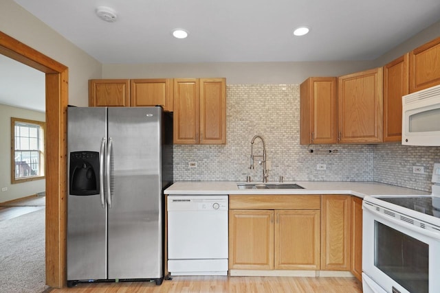 kitchen featuring backsplash, a sink, light countertops, recessed lighting, and white appliances