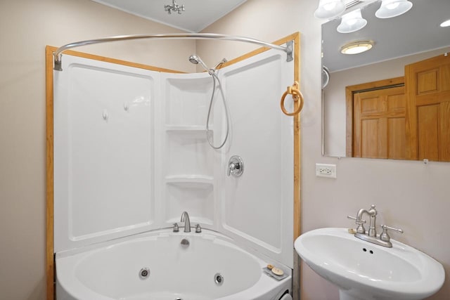 bathroom featuring a sink and a combined bath / shower with jetted tub