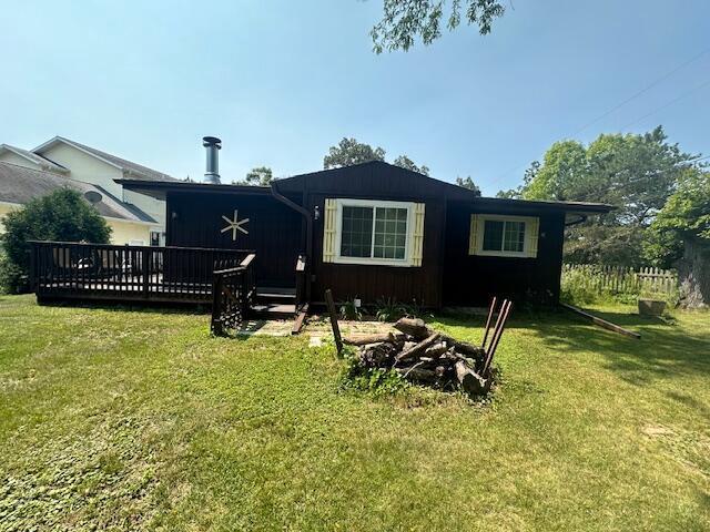 back of property with a lawn and a deck