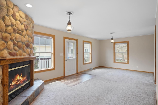 carpeted entrance foyer with baseboards and a fireplace