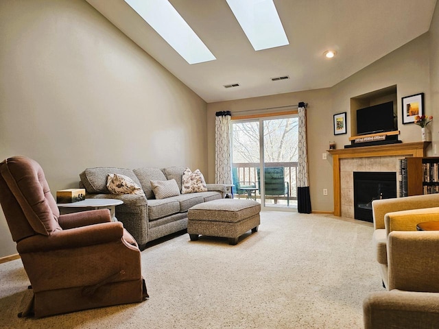 850 Evergreen Dr Unit 8, Hartford, WI 53027 - carpeted living area with visible vents, a skylight, a tile fireplace, high vaulted ceiling, and baseboards