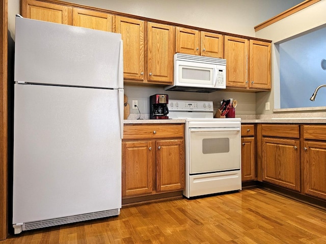 850 Evergreen Dr Unit 8, Hartford, WI 53027 - kitchen featuring light wood-type flooring, light countertops, brown cabinets, and white appliances