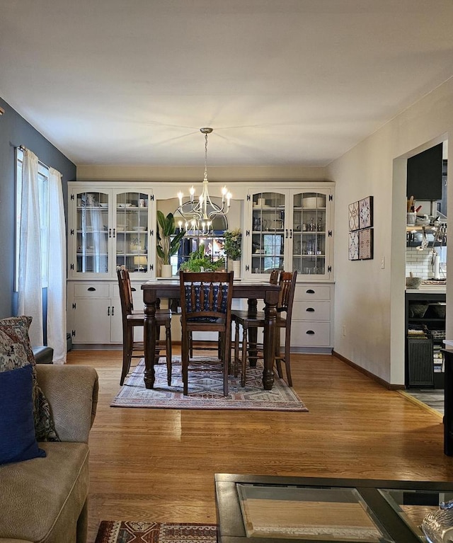 dining room with a notable chandelier and light wood-style flooring