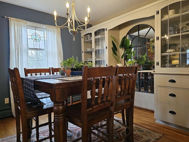 dining room with wood finished floors and a notable chandelier