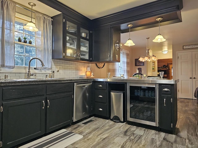 bar featuring backsplash, dishwasher, a sink, beverage cooler, and a chandelier